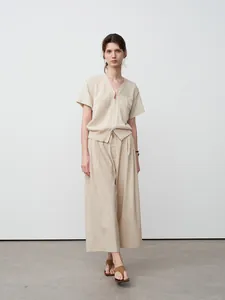 Minimalistische beige kortere broek met wijde pijpen en bijpassend gebreid bovenstuk