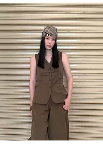Model wearing minimalist brown cotton-blend sleeveless vest and matching wide-leg pants