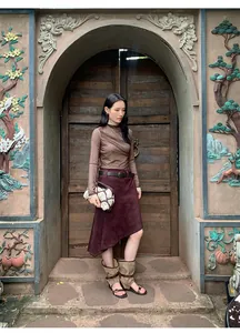 Full body shot of a woman in a retro burgundy asymmetrical Maillard-style skirt