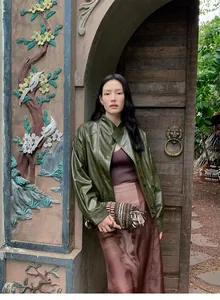 Detalle de una mujer con chaqueta vintage de cuero PU verde oliva y diseño cruzado