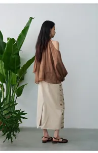 Rückansicht eines braunen Chiffon-Halter-Tops mit einer beige Maxi-Rock-Kombination