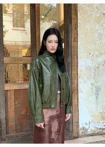 Modelo asiática con una chaqueta corta de cuero sintético verde oliva de estilo retro