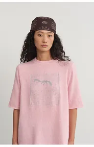 Detailed shot of pink knit top featuring unique silver thread jacquard on the front