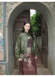 Detalle de chaqueta vintage de cuero PU verde usada por una modelo asiática en un arco