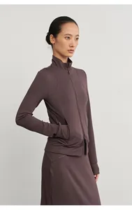 Detail view of woman wearing a brown modal knitted sports skirt and zip-up jacket