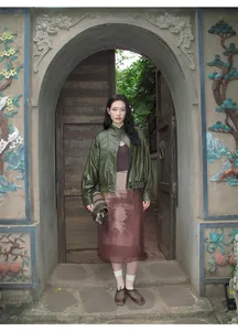 Chaqueta corta de cuero PU verde oliva vintage usada por modelo en un arco adornado