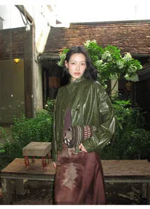 Modelo con chaqueta corta de cuero PU verde oliva retro en un jardín de estilo vintage