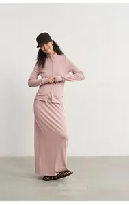 Full-length view of a woman wearing a pink knitted modal skirt set with a jacket.