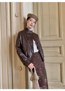 Modelo con chaqueta de cuero PU marrón vintage con cierre de botones asimétrico