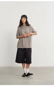 Detail view of a gray loose-fit knit top with silver jacquard and five-point sleeves.
