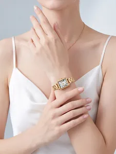 Elegante reloj de cuarzo cuadrado dorado con números romanos en la muñeca de una modelo.