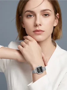Elegante quadratische silberne Quarzuhr mit Netzarmband am Handgelenk eines Models im Beruf