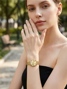 Elegant women's gold square quartz watch worn by a female model in a sunlit park setting