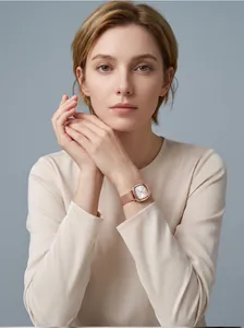 Elegante roségoldene Quarzuhr mit Milanaise-Armband am Handgelenk des Models.