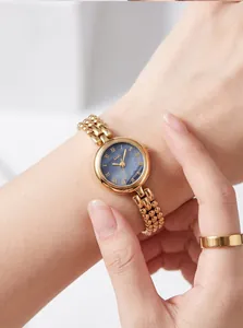 Close-up view of Gedi vintage gold quartz watch with a blue dial worn on a female wrist.