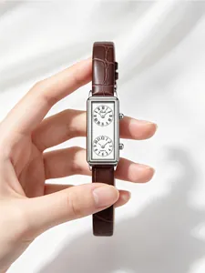 Close-up of French retro rectangular watch with double dial and brown leather strap