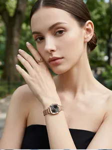 Detailed view of an elegant rose gold watch with faceted black dial on a model