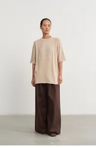 Detailed view of women's loose knit top with silver jacquard pattern and wide-leg pants