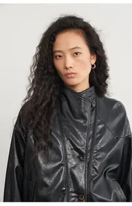 Primer plano de chaqueta vintage de cuero sintético negro con cuello de botones