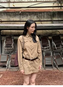 Asiatisches Model zeigt ein khakifarbenes Retro-Utility-Hemdkleid mit braunem Gürtel