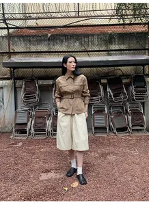 Volledig aanzicht van het retro bruine corduroy werkjasje gecombineerd met beige broek