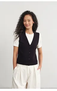 Modell trägt eine dunkelblaue Strickweste mit Knopfleiste und Polo-Kragen