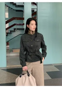 Modern autumn outfit with dark suede-style belted jacket and beige straight-leg pants