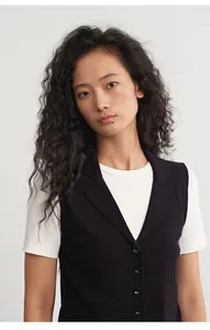 Detailansicht einer schwarzen Strickweste für Damen mit Reverskragen über weißem T-Shirt