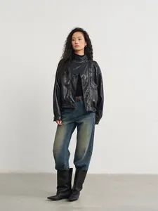 Chaqueta vintage asimétrica de cuero PU negro para mujer en estudio minimalista