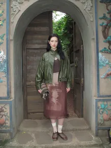 Chaqueta corta retro de cuero PU verde oliva para mujer con diseño de cierre en diagonal.