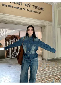 Donna con camicia di jeans lavata vintage e jeans abbinati in una sala del museo