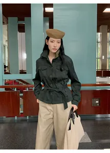 Model wearing high-waist beige PU leather wide-leg pants in a modern architectural setting