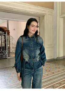 Dettaglio di giacca a camicia in denim sfumato vintage con cintura in vita su modella.