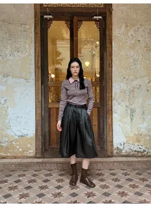 Full body view of high waist PU leather wide leg culottes on model in vintage background