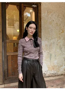 Model in high-waist black faux leather wide-leg pants with a stylish polo knit sweater
