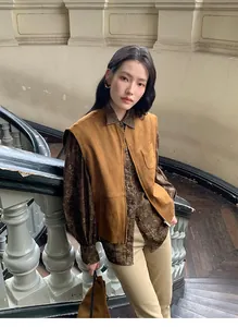 Modella che indossa un gilet di camoscio marrone vintage in un ambiente interno Maillard