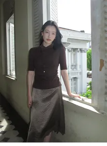 Elegant model wearing a brown satin midi skirt with delicate lace patchwork and irregular hem