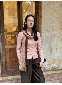 Elegant pink knit cardigan paired with a stylish brown gradient scarf on a model.