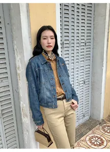 Street style view of women's short denim jacket with lapel and gradient wash finish