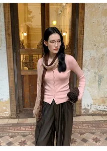 Elegant model wearing a soft pink slim-fit knitted cardigan with a matching brown scarf