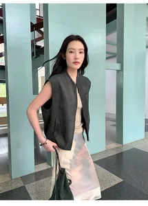 Modella asiatica con gonna midi a trapezio stampata a vita alta in un ambiente moderno