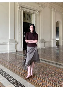 Full-length fashion view of a brown asymmetrical satin skirt with delicate lace trim