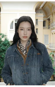 Close-up view of women's vintage gradient wash denim jacket with classic lapel collar