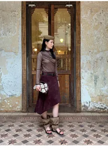 Full-body shot of a retro asymmetrical burgundy suede A-line skirt in Maillard style