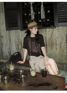 Detail view of a textured asymmetrical beige midi skirt worn in a rustic setting