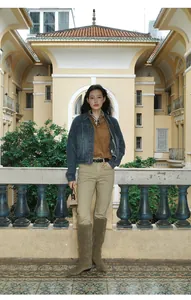Fashion model wearing a short denim jacket with gradient wash in a vintage architectural setting