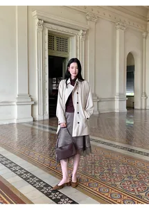 Blogger style satin midi skirt with lace trim and irregular hem worn by model in a hallway