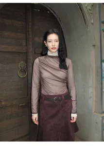 Retro Maillard style asymmetric burgundy A-line skirt worn by a model in a rustic setting