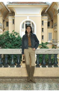 Asian model in a cropped gradient denim jacket and tall boots in a vintage setting