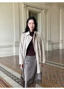 Full body view of a woman wearing a satin lace midi skirt in an ornate classic hall.